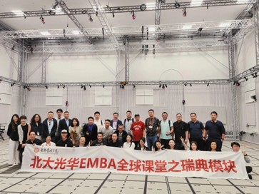 Professional educational team working together in modern office environment with laptops and documents, bright natural lighting